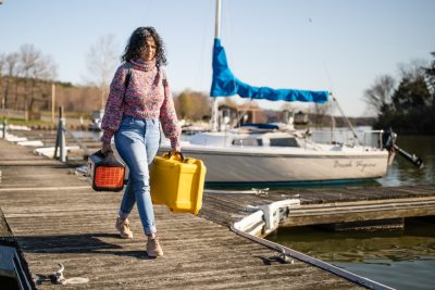 A student carrying supplies to the boat.
