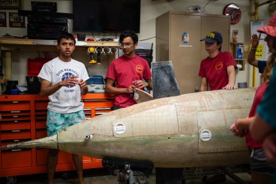 Students around the sub in the lab discuss the plans for the test pool day.