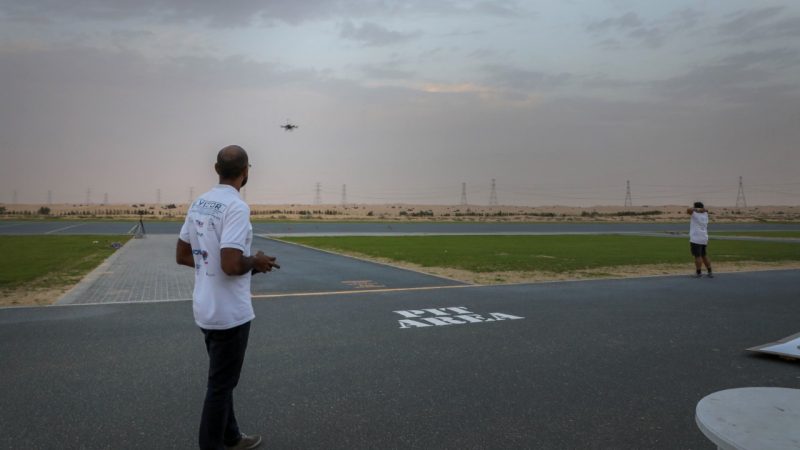 Graduate student flying a drone outside in the desert in Abu Dhabi.