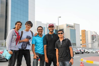 Group of five students posing for a photo in the city
