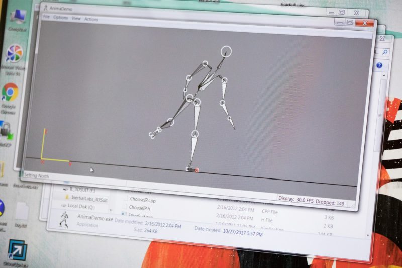 A projection of a computer screen shows the digital stick figure created by the 3D rendering software