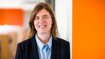 Ella Atkins posing inside with orange walls