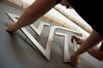 Virginia Tech logo being attached to wall. 